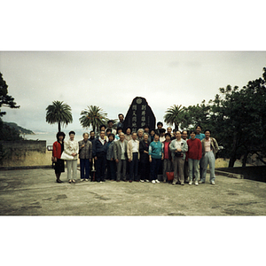 Chinese Progressive Association members gather in a group around a monument with a Chinese inscription on Angel Island