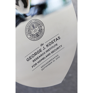 The engraving on a groundbreaking shovel reads: "the George J. Kostas Research Institute for Homeland Security Groundbreaking, September 10, 2010"