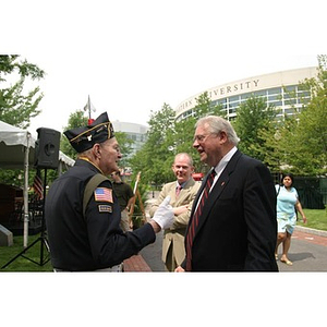 Neal Finnegan and a man converse at the Veterans Memorial groundbreaking ceremony