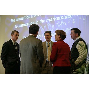 A group stands in front of a projector screen at the Training Future Innovators Entrepreneurs Panel