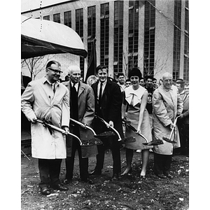 Five people hold shovels during the ground breaking for the Ell Student Center addition