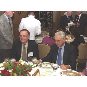 Barry Karger, left, and John Hatsopoulos sit at table at gala dinner