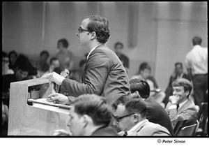 National Student Association Congress: man speaking at podium, Allard Lowenstein seated on right, wearing glasses