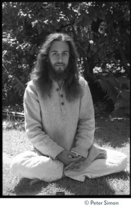 Gangadhar: portrait of the tabla player with Amazing Grace and member of Ram Dass satsang, seated in a lotus position in front of a rhododendron