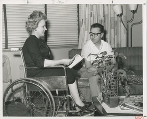 Mrs. Frances Marsala seated in her wheelchair paging through a magazine