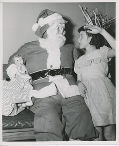 Santa Claus with young girl and bag of gifts