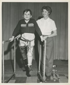 Boy using parallel bars during physical rehabilitation