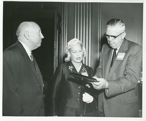 Margaret Milbank Bogert and two men admire the 1956 President's Trophy