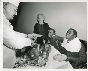 Chef Karl Larsen serving turkey to young clients Donna Robinson and Norris Powell