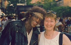 A Photograph of Marsha P. Johnson Wearing a Gold Headband, Leather Jacket and White Shirt at New York City Gay Pride 1992