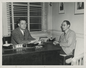 Manny Bloom, Secretary of the Communist Party of New England, seated at a desk with Sidney Lipshires