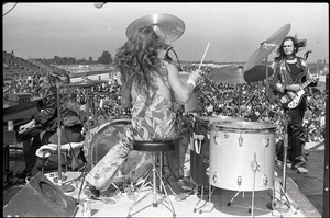 Hollywood Speedway Rock Festival: Jo Jo Gunne in performance, view from behind drummer (Curly Smith), bassist (Jimmy Randall) looking on