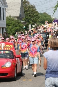 Paraders in tie-dyed shirts and pink hats : Provincetown Carnival parade