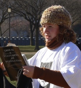 Protester on the National Mall marching against the War in Iraq, reading from a book 'This is a statement of revolution'