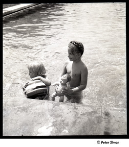 Two unidentified girls playing with a doll and inflatable ball