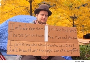 Occupy Wall Street: demonstrator in a bowler hat holding a cardboard sign