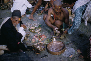 Priest handing food to a worshipper in Gokarna