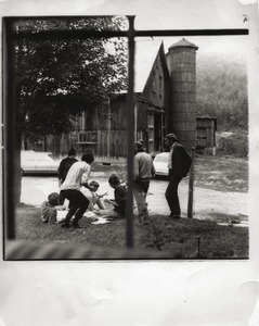 Group seated in front of the farmhouse, Montague Farm Commune