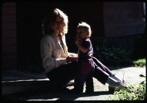 Janice Frey seated with infant Phoebe Mathews, Montague Farm Commune