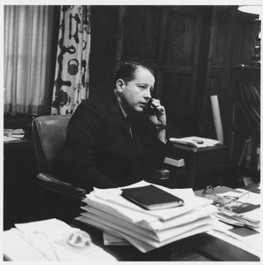 John William Ryan seated at office desk, talking on telephone