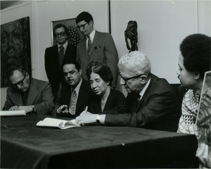 Herbert Aptheker signing paper transferring W. E. B. Du Bois papers to University of Massachusetts