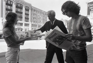 Boston Phoenix promotional photos: Phoenix hawker handing paper to man, Stephen Davis (r) reading