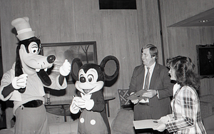 Man with Disney characters Mickey Mouse and Goofy