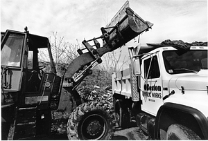 Boston Public Works truck and front-end loader on a debris-strewn lot