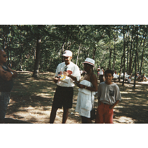 Carmen Pola stands with a man and a youth at a picnic event