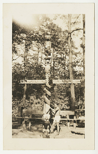 Man working on the Totem Pole in the council ring on East Campus