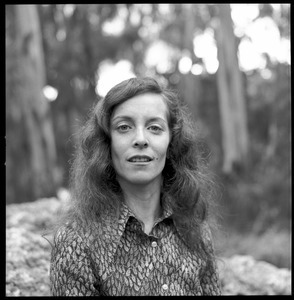 Woman posed on a granite boulder in a eucalyptus grove