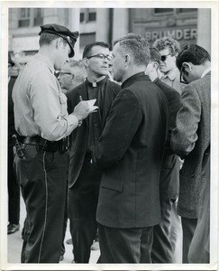 Policemen talking with some of the Milwaukee Fourteen at the small park dedicated to America's War Dead where the burning ceremonies took place