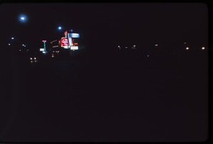 Motel signs on a strip lit up at night