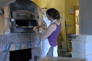 Hungry Ghost Bread: owner and baker Cheryl Maffei putting cookies into the oven