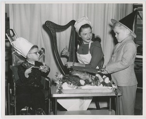 Susan Reed playing a harp with patients at Thanksgiving