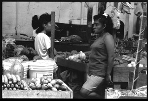 Two women at a market stall selling produce in the old marketplace, Belize City