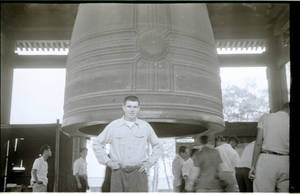 Young man in front of temple bell