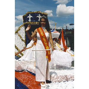 The Second Princess, Damaris Padilla, waves from a parade float at the Festival Puertorriqueño