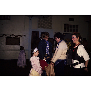 Child in costume being offered a bag by an adult