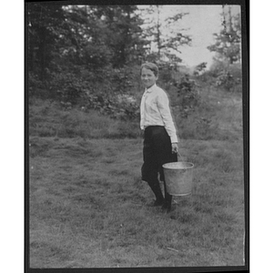 Boy hauling a pail outdoors