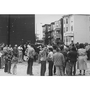 A large group of people stand informally in a circle at an outdoor rally for Mayor Raymond Flynn