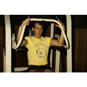 Man works out on an exercise machine in a gym