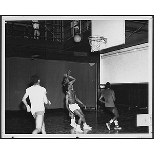 Young men playing basketball in gym