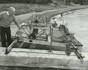 Dr. Chester Ellsworth Cross, examining a flotation sander on the state bog