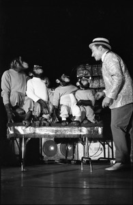 Chimpanzee vaudeville act opening for the Grateful Dead at Sargent Gym, Boston University: performer with pork-pie hat and chimpanzees balancing objects on their heads