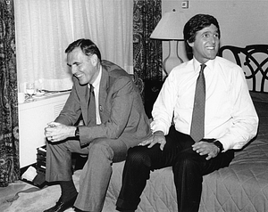 Mayor Raymond L. Flynn seated on a bed with John Kerry