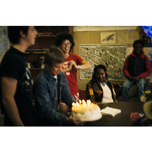 Boy carries a birthday cake to a table