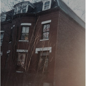 Exterior view of a three-story brick residential building in Roxbury, Mass