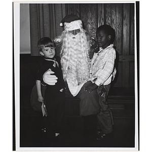 Santa Claus poses for a shot with two boys