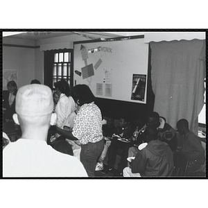 A group of children eat pizza at the Tri-Club slide show at the Charlestown Clubhouse